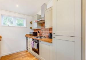 a kitchen with white cabinets and a stove top oven at Sanctuary Pathfinder Lodge in Fort Augustus