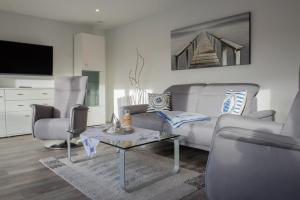 a living room with a couch and a table at Deichhöhe 7 HU in Norddeich