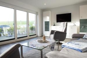 a living room with a couch and a table at Deichhöhe 7 HU in Norddeich