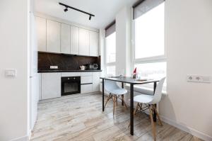 uma cozinha com uma mesa e armários brancos em Nyvky Like Home - Нивки Парк - Студія 40-2 em Kiev mais 18 fotografias