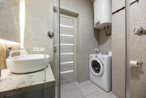 um banheiro com pia e máquina de lavar em Nyvky Like Home - Нивки Парк - Студія 40-2 em Kiev