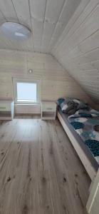 a small room with a bed and a window at Biały Sztorm in Rusinowo