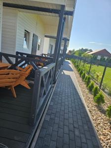 a porch of a house with a wooden bench at Biały Sztorm in Rusinowo
