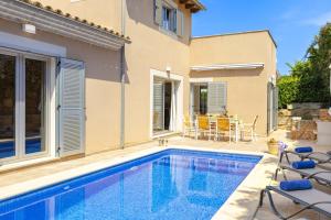 a swimming pool in front of a house at Villa Synera in Alcudia
