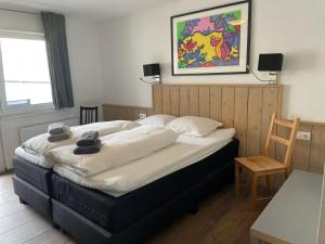 a large bed in a room with a chair at Apart AUSTRIA in Finkenberg