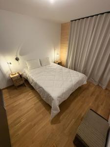 a bedroom with a white bed and wooden floors at Vars Livingstone in Vars