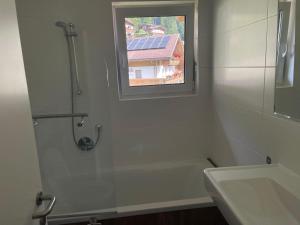 a bathroom with a shower and a sink and a window at Apart AUSTRIA in Finkenberg