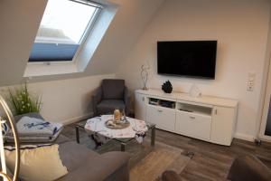 a living room with a flat screen tv on a wall at Deichhöhe 7 HO 1 in Norddeich +5 photos