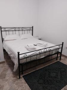 Bett mit schwarzem Rahmen sowie weißer Bettwäsche und Kissen in der Unterkunft VILLA SIMONA Malpensa Samarate in Samarate