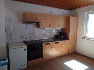 a kitchen with wooden cabinets and a stove top oven at Monteurhaus LK1 in Lissendorf