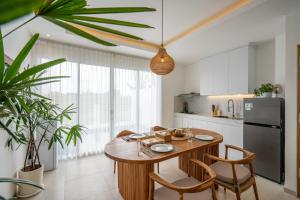 a kitchen with a wooden table and chairs and a refrigerator at Sunrise Bliss 15 Ricefield View Private Pool Villa By Bali Bliss Properties in Dalung
