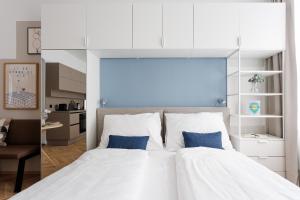 a bedroom with a large white bed with two blue pillows at Urban Hideaway Vienna in Vienna