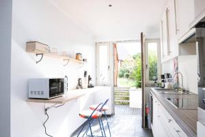 a white kitchen with a counter and a microwave at Kaze - Bienvenue chez vous in Grimbergen
