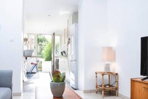 a living room with white walls and a tv at Kaze - Bienvenue chez vous in Grimbergen