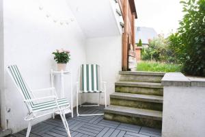 two chairs sitting on a patio with stairs at Kaze - Bienvenue chez vous in Grimbergen