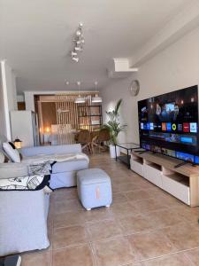 a large living room with a large flat screen tv at Peaceful Garden Cottage -Walking to the Beach in Bicas +25 photos