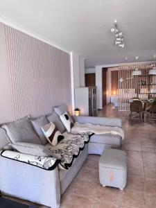 a living room with a couch and a dining room at Peaceful Garden Cottage -Walking to the Beach in Bicas