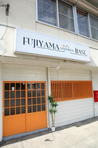 um edifício com portas laranja e um sinal nele em Fujiyama Base em Fujiyoshida