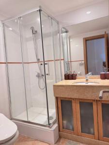 a bathroom with a shower and a toilet and a sink at Peaceful Garden Cottage -Walking to the Beach in Bicas