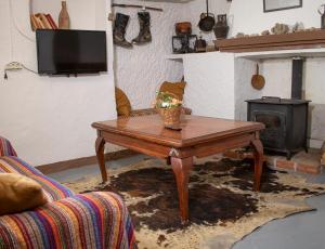a living room with a wooden coffee table and a fireplace at Cueva Navarro in Gorafe