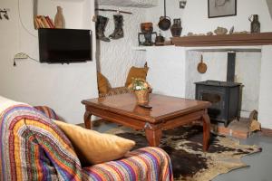 a living room with a table and a wood stove at Cueva Navarro in Gorafe