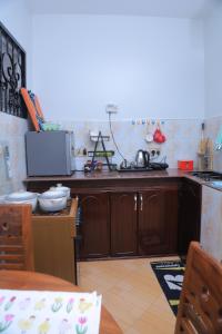 a kitchen with wooden cabinets and a sink at Ecohaven cottage in Entebbe