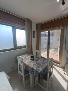 a dining room with a table and chairs and windows at Estudio Centro A Guarda in A Guarda +3 photos