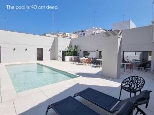 un patio con piscina, sedie e tavoli di Numa Valencia El Carmen a Valencia Altre 33 foto