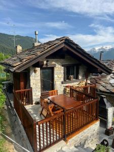 a small house with a wooden deck and a table at L'Atelier du Temps - Casa Torre in Challancin