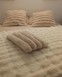 a white bed with two pillows on top of it at Chalet Barbarine au coeur des 3 Vallées in La Combe