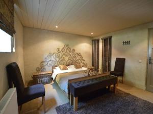 a bedroom with a bed and a bench and chairs at Group Stay with Private Pool and Sauna in Alphen