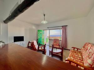 ein Wohnzimmer mit Tisch und Stühlen und einem Fernseher in der Unterkunft Vista Paraiso 2 in Mácher