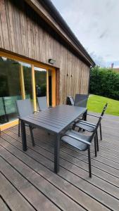 a picnic table and chairs on a wooden deck at U Bobra sjezdaře in Dolní Morava