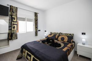 a bedroom with a bed with black and gold sheets at Apartamento Alba Lanzarote in Puerto del Carmen