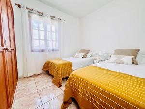 ein Schlafzimmer mit zwei Betten und einem Fenster in der Unterkunft Vista Paraiso 2 in Mácher