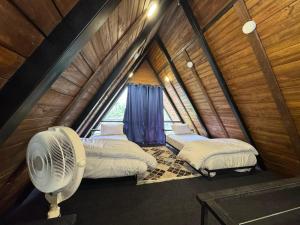 a room with two beds and a fan in a attic at Gumaan Resort in Skardu +56 photos