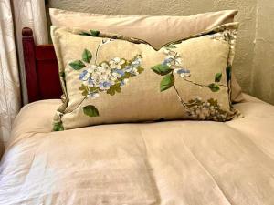 a bed with two pillows with flowers on it at De Kaapse Rust Boutique Guesthouse & Venue in Parys