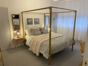 a bedroom with a canopy bed and a night stand at Seaglass No2 - Luxury 3 bed with optional hot tub in Seaham