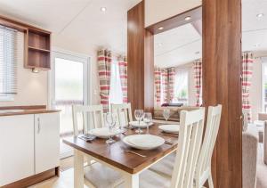 a kitchen and dining room with a wooden table and chairs at The Ness Hot tub Lodge in Fort Augustus
