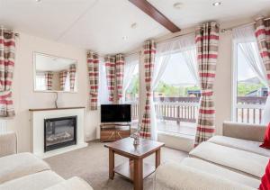 a living room with a fireplace and a television at The Ness Hot tub Lodge in Fort Augustus