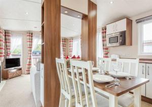 a kitchen and dining room with a table and chairs at The Ness Hot tub Lodge in Fort Augustus