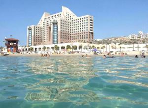 a view of a beach with people in the water at Sea Vacation in Haifa