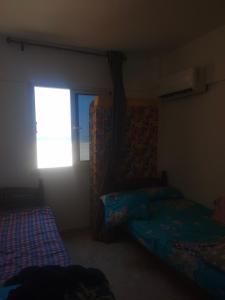a bedroom with two beds and a window at شاليه in Marsa Matruh