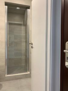 a glass shower in a bathroom next to a door at Mini Apartman - Parking free - 5 min center in Nitra +2 photos
