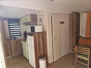 Cabrières-dʼAiguesにあるCamping Onlycamp Les Chênes Vertsの冷蔵庫とテーブルのある小さなキッチン +2枚の写真
