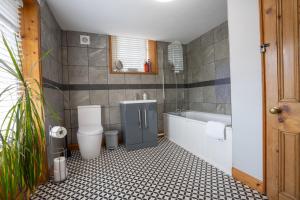 une salle de bain avec toilettes, baignoire et lavabo dans l'établissement Heritage Swiss Cottage, à Matlock Bank 26 autres photos
