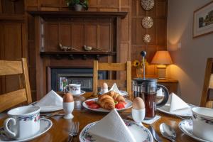 une table avec une assiette de croissants et d'œufs dans l'établissement Heritage Swiss Cottage, à Matlock Bank