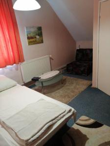a bedroom with two beds and a couch at Flamingó Étterem Szálláshely in Somlójenő +20 photos