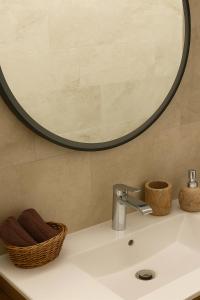 lavabo con espejo redondo encima en Escala - Family Room, en Fully 16 fotos más