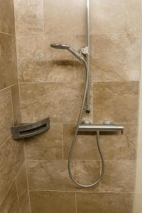 una ducha con cabezal de ducha en un baño en Escala - Family Room, en Fully